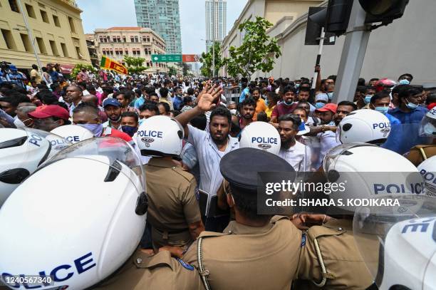 Government supporters and police confront each other outside the President's office in Colombo on May 9, 2022. - Violence raged across Sri Lanka late...