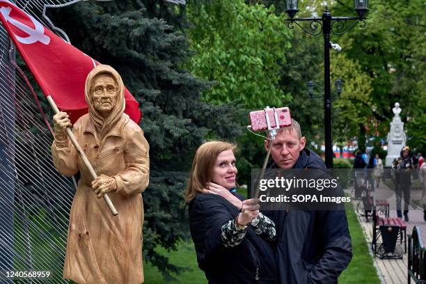 Couple takes a selfie with Donbass grandmother, a propaganda symbol of military aggression, on the 77th anniversary of the Victory Day in Voronezh....