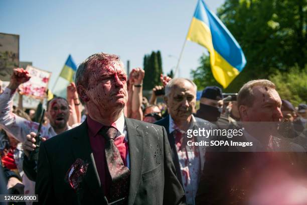 Russia's ambassador to Poland, Sergey Andreev covered in red paint leaves the Soviet soldiers cemetery. Hundreds of Ukrainians and Polish activists...