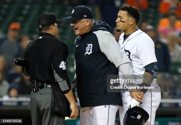 Manager A.J. Hinch of the Detroit Tigers gets between Javier Baez and home plate umpire Nick Mahrley after Baez was ejected for arguing after being...