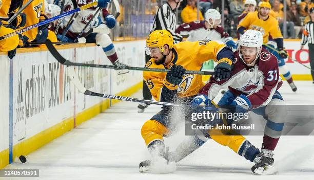 Compher of the Colorado Avalanche battles for the puck against Alexandre Carrier of the Nashville Predators in Game Four of the First Round of the...
