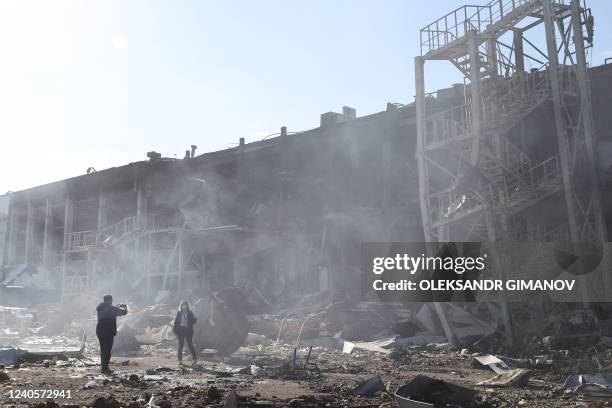 Onlookers take pictures in front of the shopping and entertainment center in the Ukrainian Black Sea city of Odessa on May 10 destroyed after Russian...