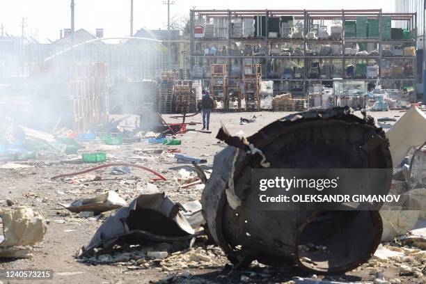 Man walks past fragments of missiles in front of the shopping and entertainment center in the Ukrainian Black Sea city of Odessa on May 10 destroyed...