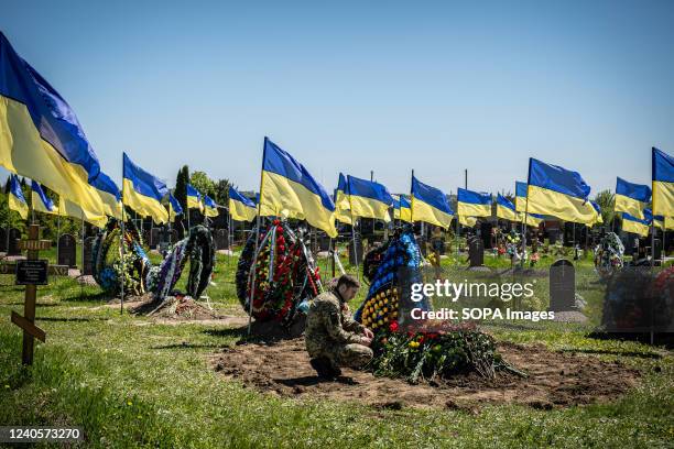 Ukrainian soldier mourns in front of his comrade's tomb at a cemetery in Dnipro. Following the invasion of Ukraine, marking the biggest military...