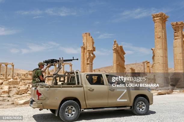 Russian forces' "technical" drives past the remains of the Triumphal Arch of Septimius Severus built during the reign of the 3rd-century Roman...