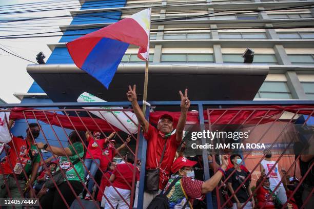 Supporters of Philippine presidential candidate Ferdinand Marcos Jr celebrate outside his campaign headquarters after his landslide presidential...