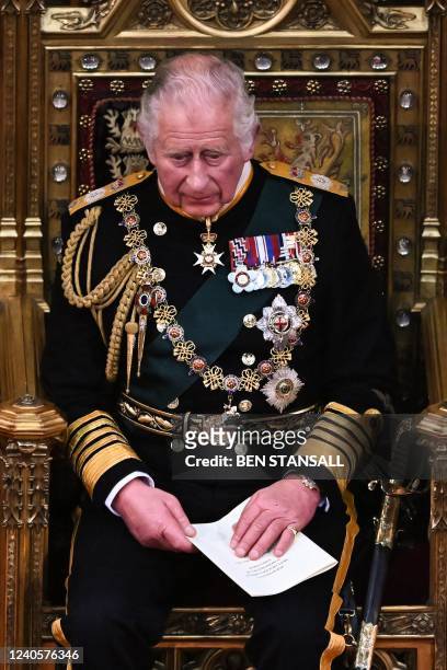 Britain's Prince Charles, Prince of Wales reacts after reading the Queen's Speech as he holds it in his hands in the House of Lords Chamber during...