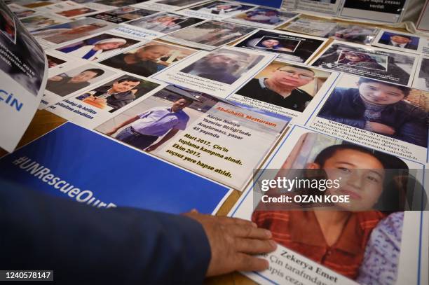 Members of Muslim Uyghur minority present pictures of their relatives detained in China during a press conference in Istanbul, on May 10, 2022. -...