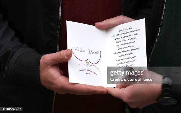 May 2022, Saxony-Anhalt, Magdeburg: Queer couple Falko and Dennés hold a card after a blessing ceremony in the Episcopal Church of Saint Sebastian in...