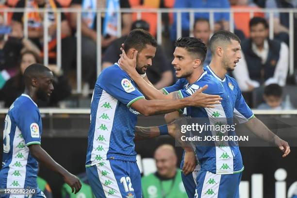 Real Betis' Brazilian midfielder Willian Jose celebrates with teammate Real Betis' Spanish defender Marc Bartra after scoring a goal during the...