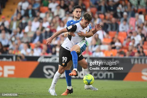 Valencia's Spanish forward Hugo Duro vies with Real Betis' Spanish defender Marc Bartra during the Spanish league football match between Valencia CF...