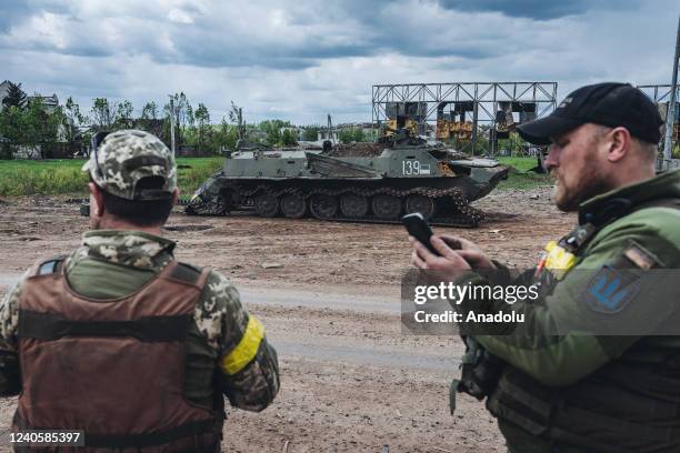 Ukrainian soldiers in front of a damage BMP on the outskirts of Kharkiv in Ukraine, on May 10, 2022.