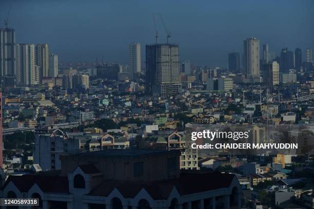 This photo taken on May 10, 2022 shows a general view of Manila from the business district of Makati. - For Ferdinand "Bongbong" Marcos Jr, who won...