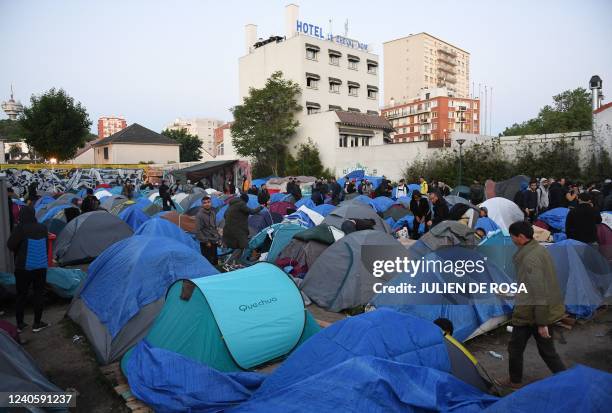 Asylum seekers, mainly from Afghanistan, stand by tents during the evacuation of a camp by police forces in Pantin, northeastern suburbs of Paris, on...