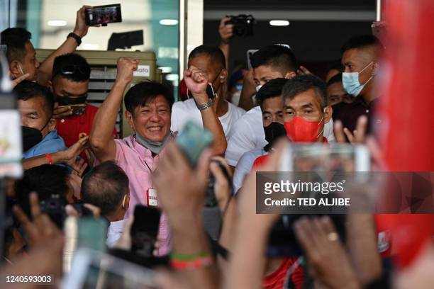 Presidential candidate Ferdinand Marcos Jr celebrates with supporters as he arrives at the campaign heaquarters in Manila on May 11, 2022. - The son...