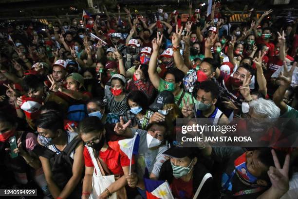 Supporters of Philippine presidential candidate Ferdinand Marcos Jr celebrate outside his campaign headquarters after his landslide presidential...