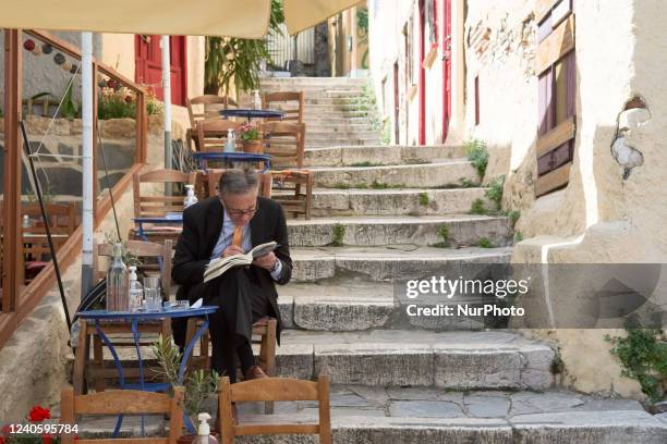 Man enjoy his coffee on a cafe in Plaka district in Athens, Greece on May 11, 2022.