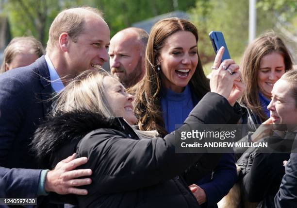 Britain's Prince William, Duke of Cambridge and Britain's Catherine, Duchess of Cambridge pose for a selfie photograph with members of the public...