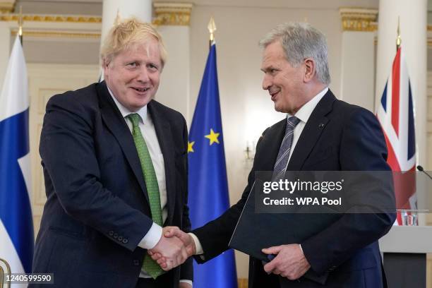 Prime Minister Boris Johnson, left, and Finland's President Sauli Niinisto shake hands at the Presidential Palace on May 11, 2022 in Helsinki,...