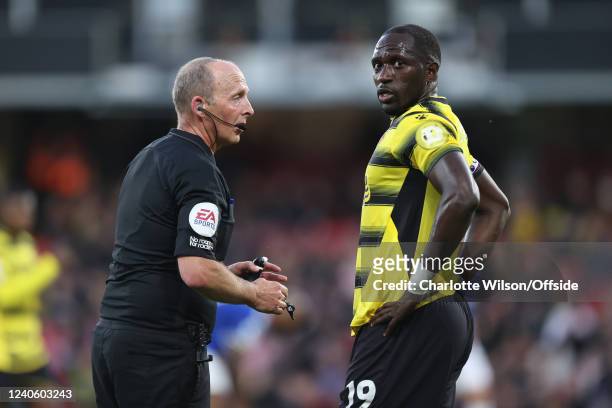 Referee Mike Dean is conversation with Moussa Sissoko of Watford during the Premier League match between Watford and Everton at Vicarage Road on May...