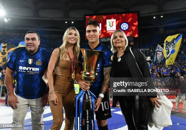 Inter Milan's Argentine forward Lautaro Martinez , holding the winner's trophy, celebrates with his partner Augustina Gandolfo and relatives, after...