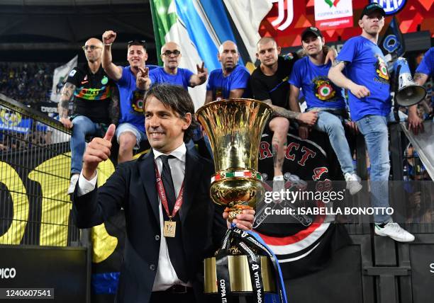 Inter Milan's Italian head coach Simone Inzaghi holds the winner's trophy as he celebrates with fans after Inter won the Italian Cup final football...