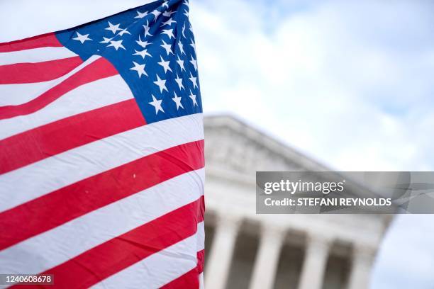 An anti-abortion demonstrator waves an American flag in front of the US Supreme Court in Washington, DC, on May 11, 2022. - Senate Democrats today...