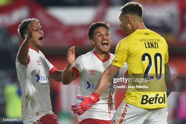 Federico Lanzilotta of Argentinos Juniors celebrates with teammates Kevin Mac Allister and David Zalazar after winning a penalty shootout during a...