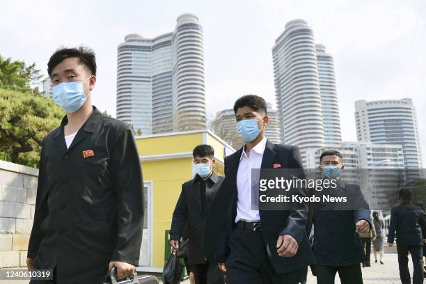 People wearing face masks walk in Pyongyang on May 6, 2022. North Korea's state-run media reported on May 12 that the country had detected the...