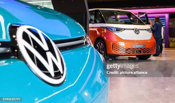 May 2022, Lower Saxony, Wolfsburg: A Volkswagen ID.3 electric car and an ID.Buzz electric bus are parked in the Autostadt at the Volkswagen main...