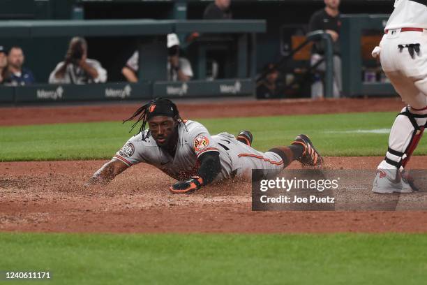 Robinson Chirinos of the Baltimore Orioles slides safely into home play for a run against the St. Louis Cardinals during the fifth inning at Busch...