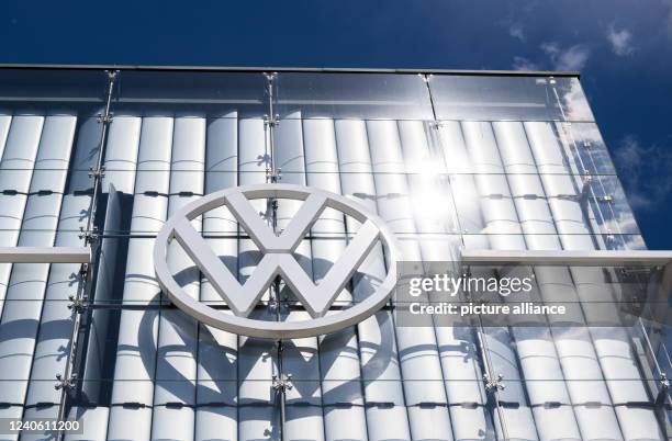 May 2022, Lower Saxony, Wolfsburg: A Volkswagen logo gleams in the sun in the Autostadt at the Volkswagen main plant. The Annual General Meeting of...