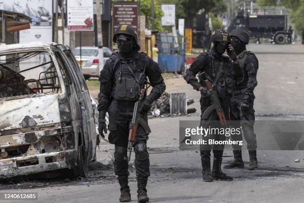 Sri Lankan Army Commando Regiment officers patrol by a destroyed vehicle on the street during a curfew in Negombo, Sri Lanka, on Wednesday, May 11,...