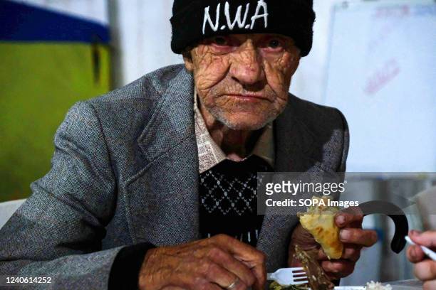 An old man eats some food after a long trip from Mariupol at the center for displaced people in Zaporizhia. Every day, displaced people from all over...