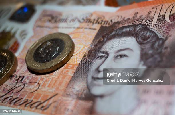 In this photo illustration, British currency in the form of two one pound coins rest atop a Bank of England ten pound note featuring an image of...