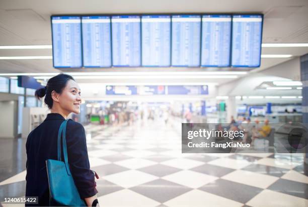 rückansicht der jungen chinesischen geschäftsfrau am abflugterminal des flughafens - ohare airport stock-fotos und bilder
