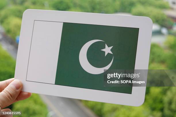 In this photo illustration, the national flag of Pakistan is printed on a white card.