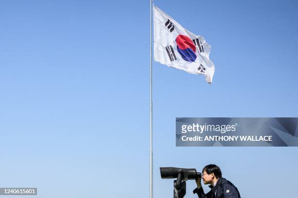 Visitor uses binoculars to look towards the North Korean side of the Demilitarised Zone from the Odusan Unification Tower in Paju on May 12, 2022.