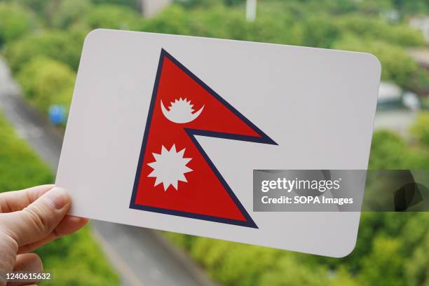 In this photo illustration, the Nepal's national flag is printed on a white card.