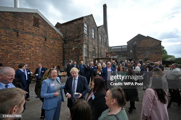 Britain's International Trade Secretary Anne-Marie Trevelyan reacts as Britain's Prime Minister Boris Johnson talks with local business leaders after...