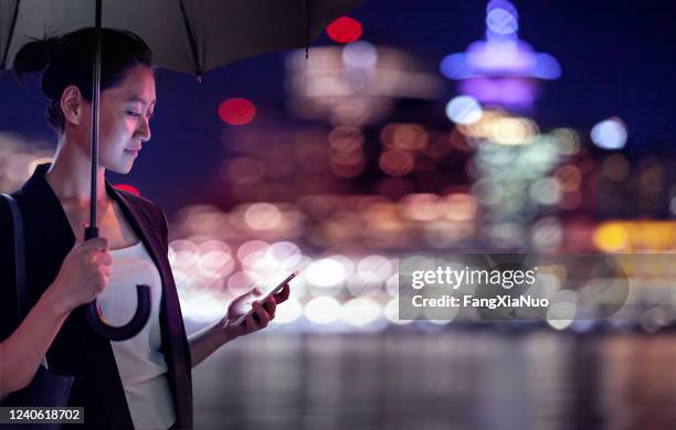 young chinese businesswoman with umbrella chatting in social media in vancouver - center for asian american media stock pictures, royalty-free photos & images