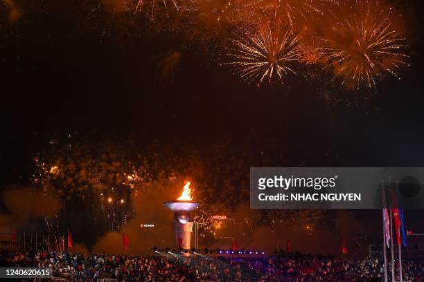 Fireworks explode over the flame in the My Dinh National Stadium during the opening ceremony of the 31st Southeast Asian Games in Hanoi on May 12,...