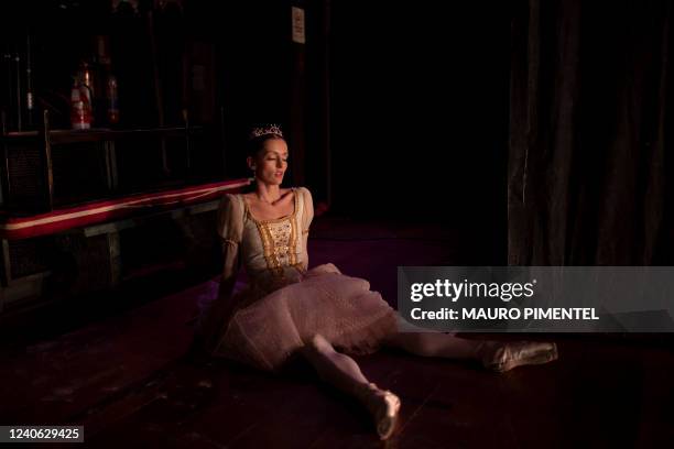 Ballet dancer rests during the rehearsal of 'Swan Lake' at the Municipal Theatre of Rio de Janeiro in Rio de Janeiro, Brazil, on May 12, 2022.