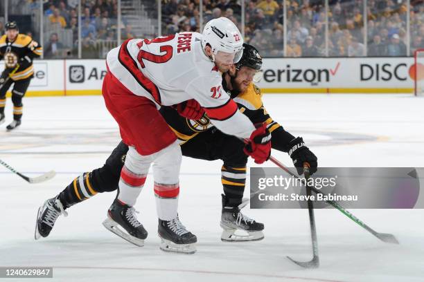 Brett Pesce of the Carolina Hurricanes fights for the puck against David Pastrnak of the Boston Bruins in Game Six of the First Round of the 2022...