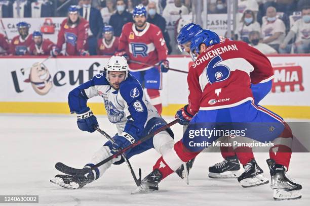 Gabriel Fortier of the Syracuse Crunch plays the puck past Corey Schueneman of the Laval Rocket during the first period in Game Three of the North...