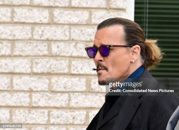 Johnny Depp smokes a cigarette as he returns from a recess outside court during the Johnny Depp and Amber Heard civil trial at Fairfax County Circuit...