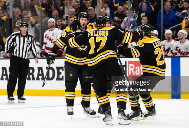 Derek Forbort of the Boston Bruins celebrates his goal during the third period against the Carolina Hurricanes with teammates Nick Foligno, Curtis...