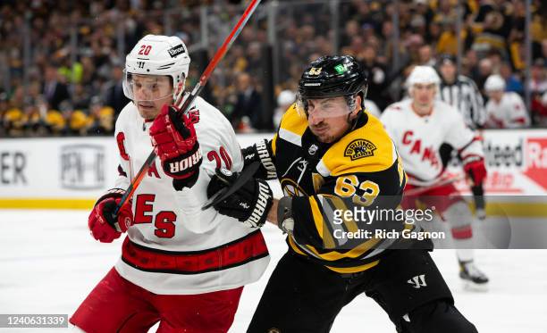 Brad Marchand of the Boston Bruins checks Sebastian Aho of the Carolina Hurricanes during the second period in Game Six of the First Round of the...