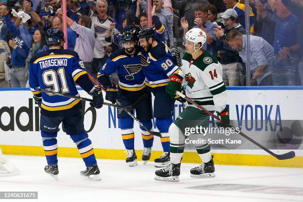 Joel Eriksson Ek of the Minnesota Wild skates past Nick Leddy, Ryan OReilly, and Vladimir Tarasenko of the St. Louis Blues as they celebrate Leedy's...