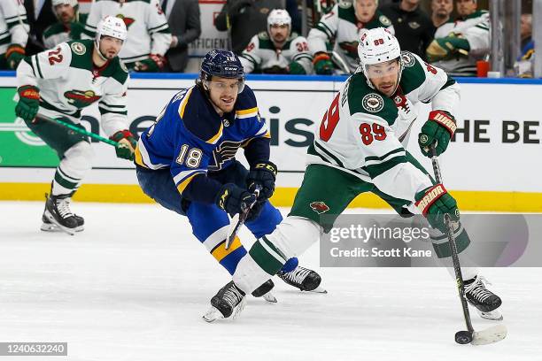 Frederick Gaudreau of the Minnesota Wild handles the puck while under pressure from Robert Thomas of the St. Louis Blues during the second period in...